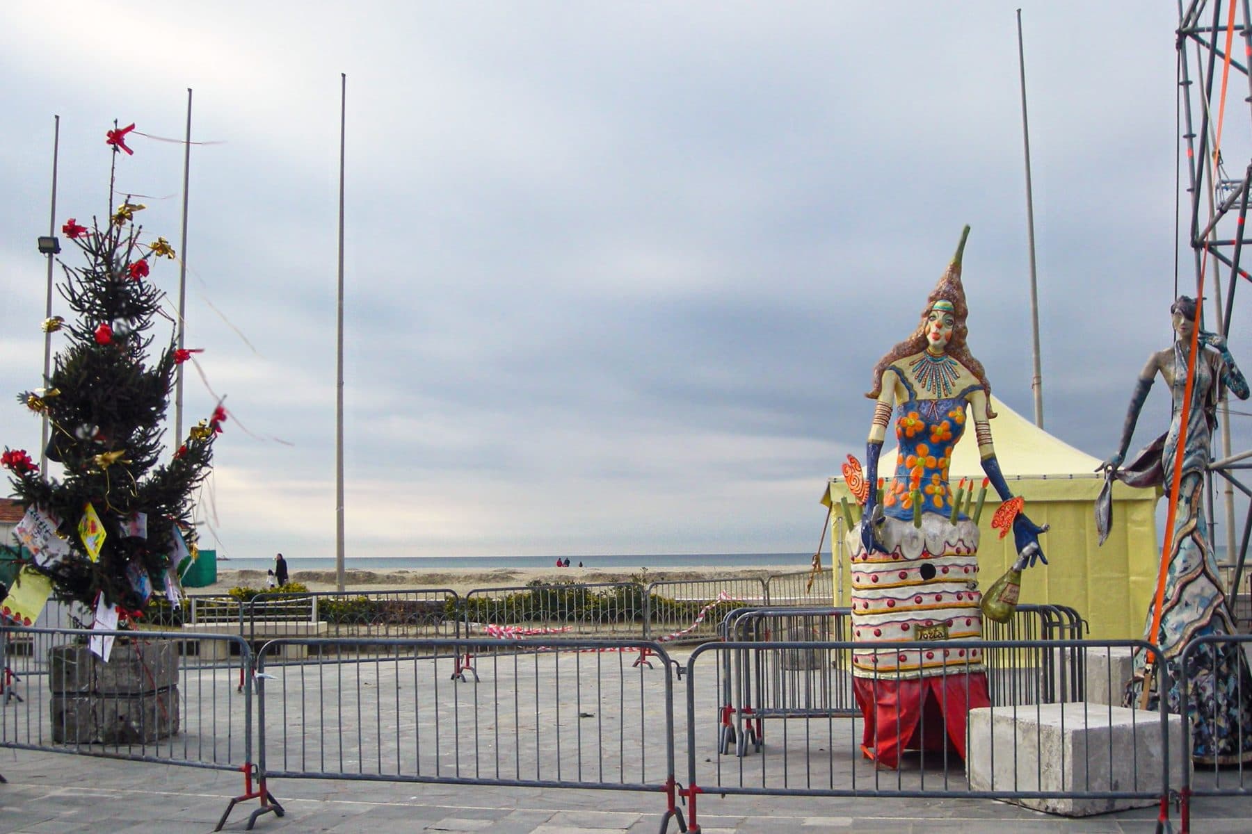 Il lungomare di Viareggio d'inverno con l'albero di Natale, le figure di cartapesta del Carnevale e la spiaggia deserta sullo sfondo